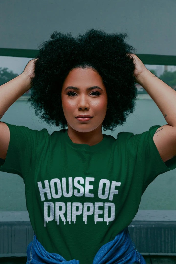 A person wearing a House of Dripped green heavyweight cotton streetwear t-shirt with white logo text.